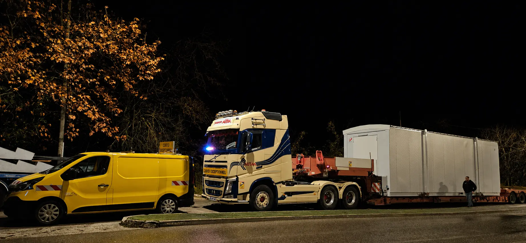 Voiture pilote accompagnant un convoi exceptionnel de nuit